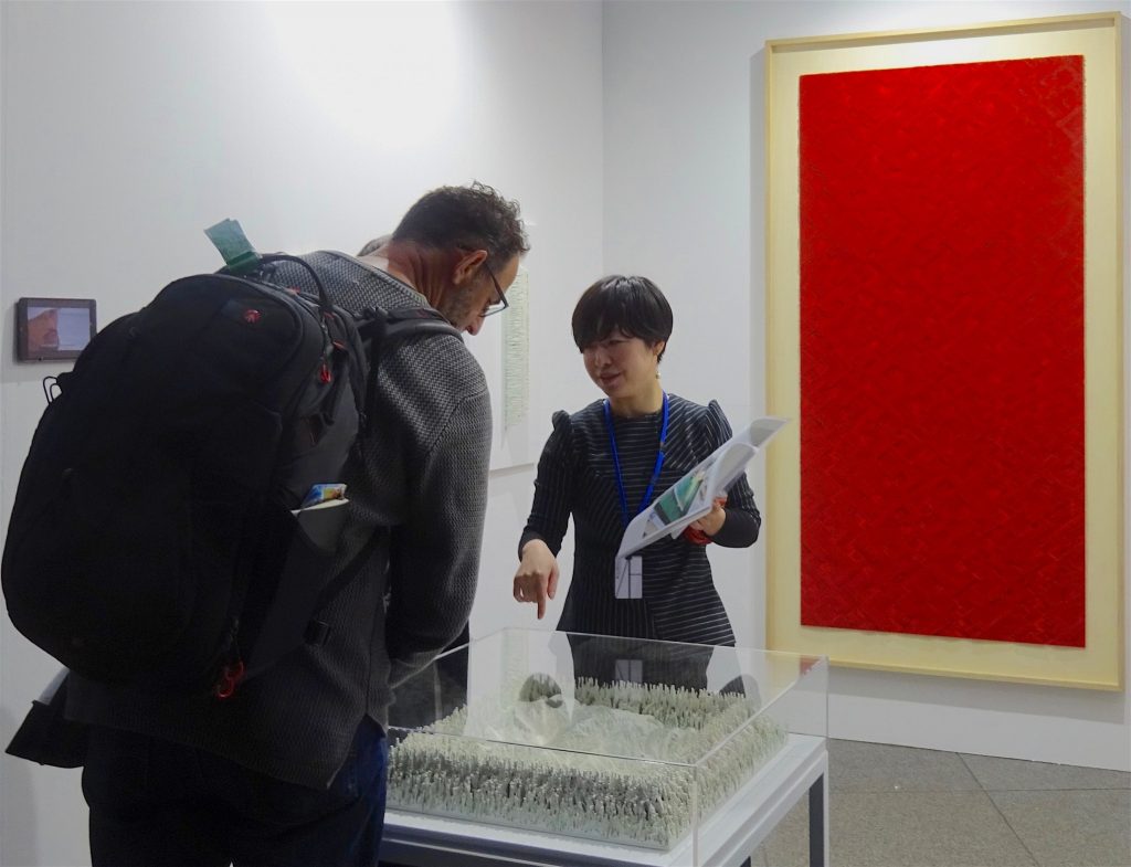 KAYOKOYUKI booth, gallery owner YUKI Kayoko 結城 加代子, explaining the works by IMAMURA Yohei 今村洋平
