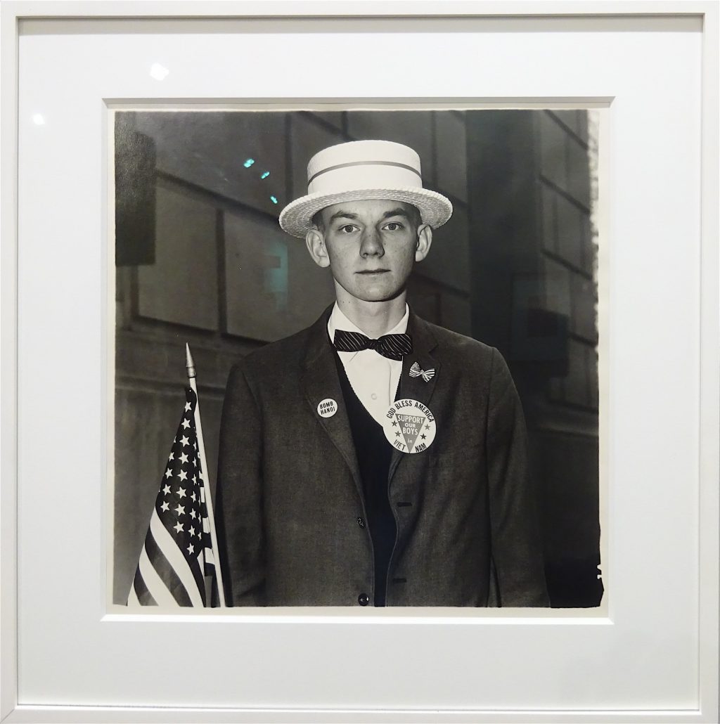 Diane Arbus “A Boy with a Straw Hat Waiting to March in a Pro-War Parade (N.Y.C. 1967)”
