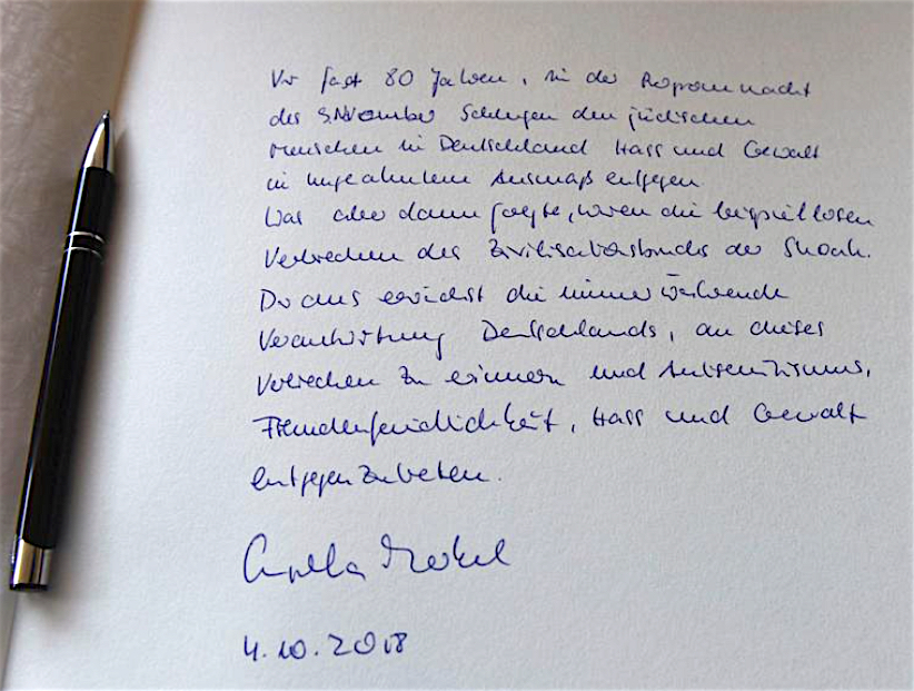 Chancellor Angela Merkel signing the guest book at Yad Vashem World Holocaust Remembrance Center in Jerusalem October 2018