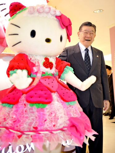 Shintaro Tsuji, founder and president of Sanrio Co., smiles as he poses with a Hello Kitty model at a Sanrio shop in Tokyo