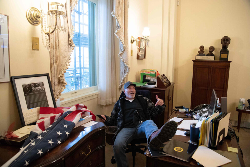 A supporter of President Trump sits inside Speaker Pelosi’s office 2021-1-6