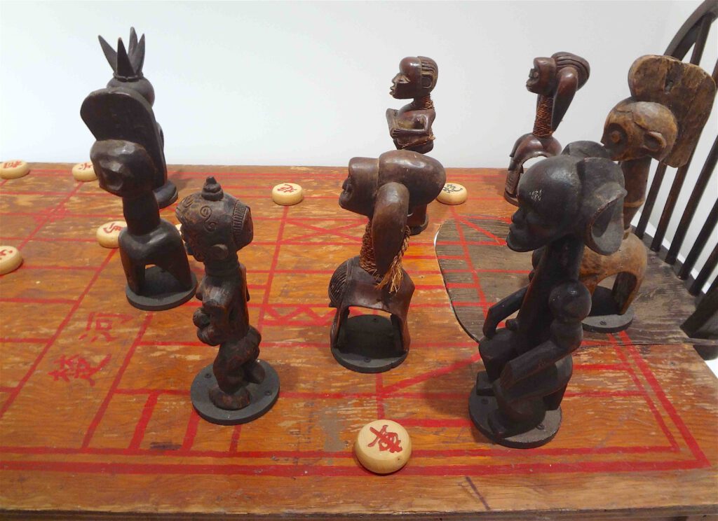 Chen Zhen “Couldn’t Bananas Be Black” 1999, Wood, chairs, African statuettes, Chinese chess, detail2