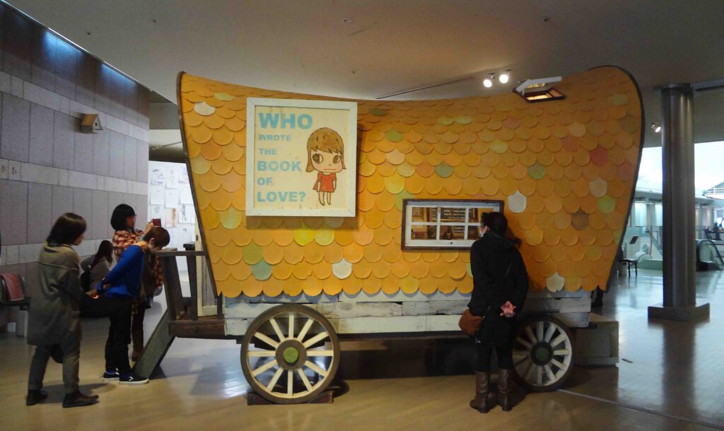 奈良美智 NARA Yoshitomo California Orange Covered Wagon 2008. Installation (acrylic on wood, recovered windows and table, metal) , 243.8 x 315.0 x 464.8 cm. MURAKAMI Takashi 村上隆 Collection