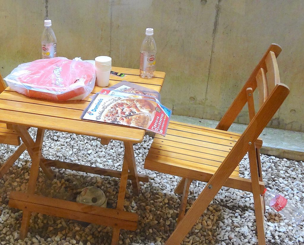 橋本聡 HASHIMOTO Satoshi Fw Pizza Delivery 2014. Menu of pizza delivery, chairs, table. Detail