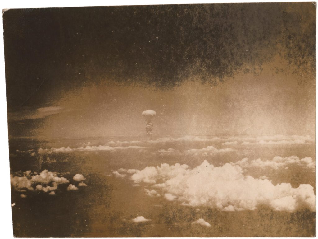 Nagasaki, Atomic Bomb, explosion 20,00 ft alt, 100 miles away, August 9, 1945, vintage gelatin silver print on glossy fiber-based paper, titled in blue ink on the reverse, 9 x 12 cm